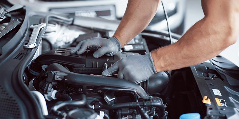 Tom Clark Chevrolet in Denton TX close up of technician checking the fluids in an engine
